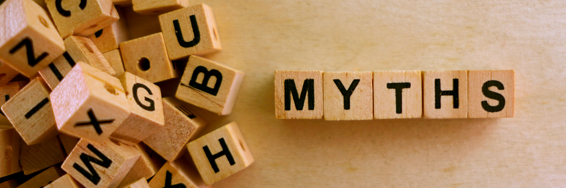 wooden letter blocks in a pile with the word myths separated and spelled out